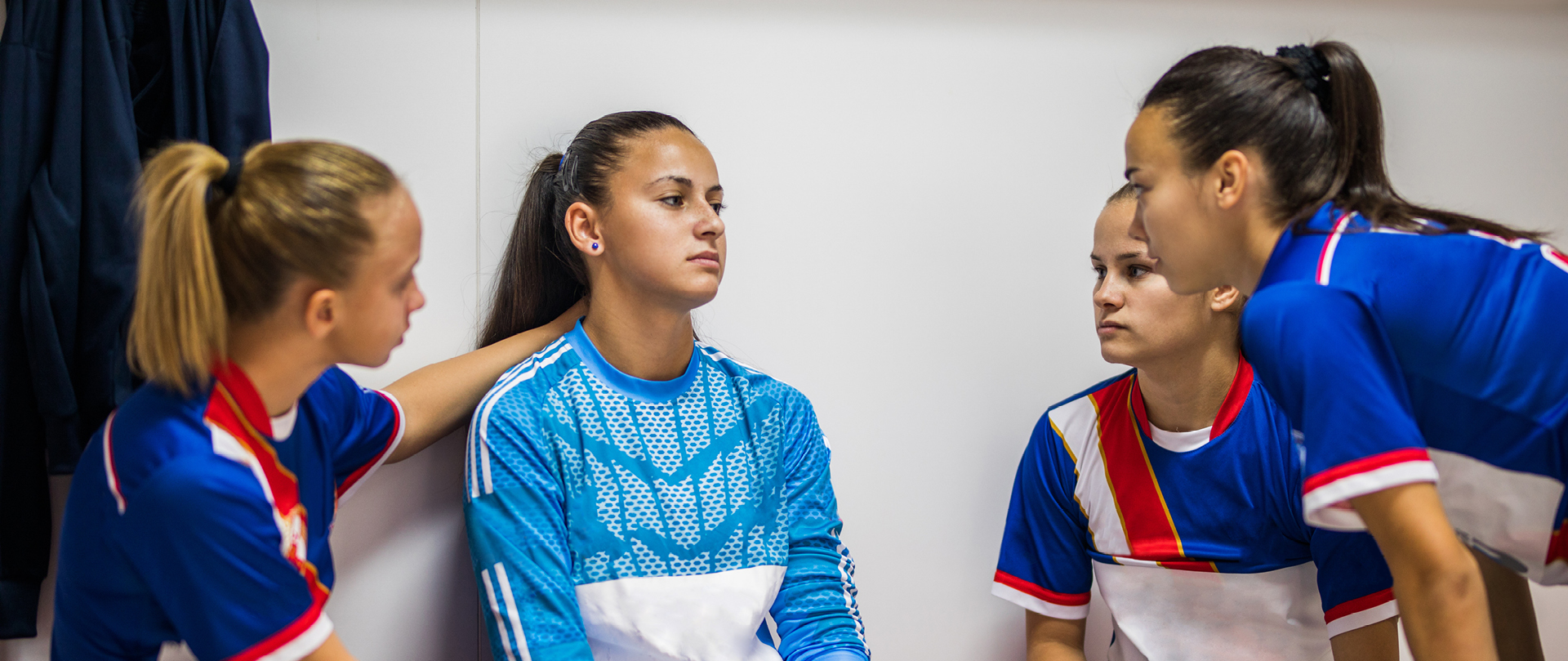 Image de quatre jeunes sportives en train de discuter dans les vestiaires
