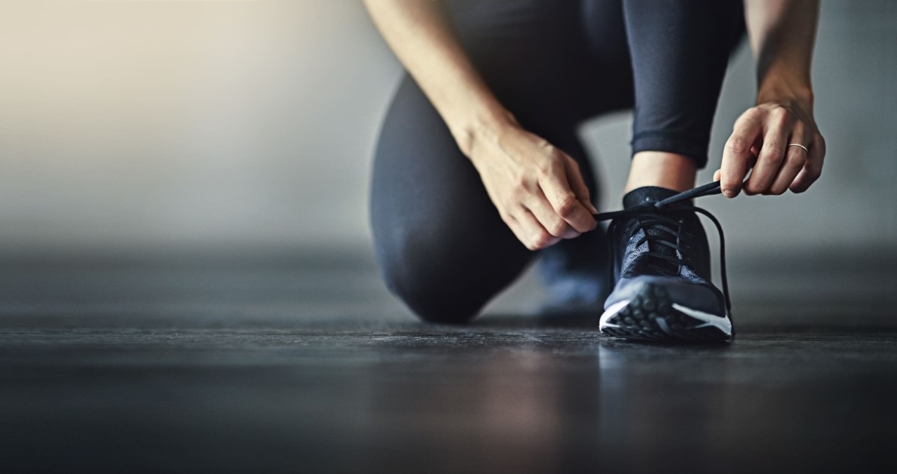 Femme sportive en train de lacer ses chaussures de sport