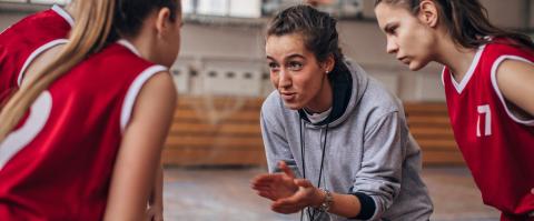 entraîneuse encourage son équipe de basketball dans une salle de sport