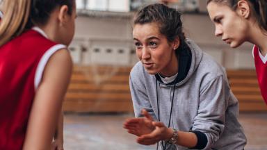 entraîneuse encourage son équipe de basketball dans une salle de sport