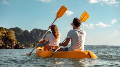Une femme et un homme ramant en canoë en pleine mer